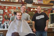 Pete Klein, center, and Mark Kern, right, co-owners of 7th Street Barbers, with a customer in the chair.