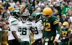 New York Jets defensive end John Franklin-Myers, left, celebrates with teammates after sacking Green Bay Packers quarterback Aaron Rodgers (12) during
