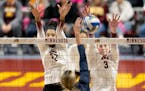 Minnesota’s Carter Booth (52), left, and McKenna Wucherer (3) block at the net against Illinois earlier this season.