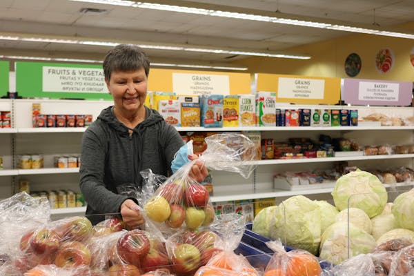 At the Interfaith Outreach Food Shelf in Plymouth, a volunteer restocked the fresh produce.