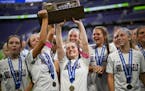 Holy Angels player celebrate with their trophy after defeating Mahtomedi in the girls' Class 2A soccer state championship gam.