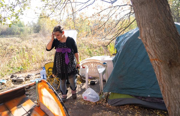 Sara Schmitz looks around her campsite Friday, Oct. 21, 2022 in St. Paul, Minn. Schmitz is experiencing homelessness but has a housing voucher and mov