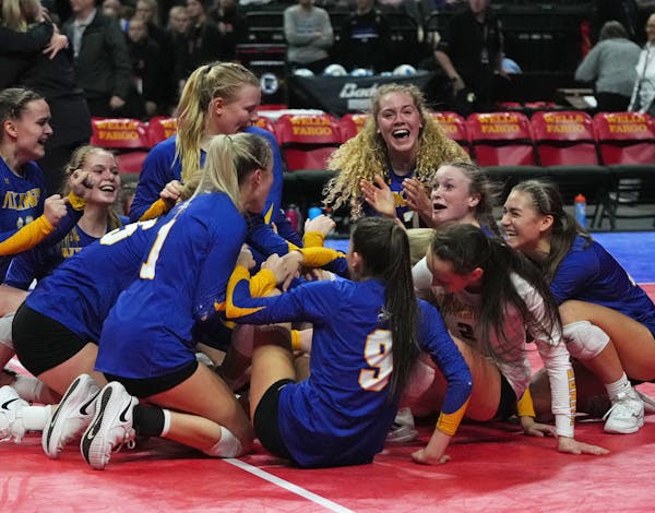 Minneota’s players formed a happy heap after they won the Class 1A volleyball state championship.