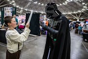 Ethan Hagen, 11, as Frodo of the Lord of the Rings tells Darth Vader aka Derek Plymate about his R2D2 figurine at Twin Cities Con in Minneapolis on Su