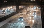 Traffic travels west near the Interstate 94 and Interstate 35W interchange as snow falls on Nov. 14 in Minneapolis.
