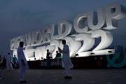 People pose for a photograph with a sign reading in English” Fifa World Cup, Qatar 2022” at the corniche in Doha, Qatar, Thursday, Nov. 17, 2022. 