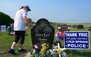 Rosella Decker, the mother of Tommy Decker, who was shot to death while working as a Cold Spring police officer in November 2012, put a hand on his gr