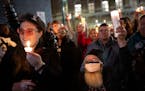 Mitch Grauberger, of Columbia Heights, and Lou Zurn, left, of Minneapolis, raised their candles after a speech by Minneapolis City Council President A