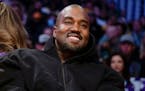 FILE - Kanye West watches the first half of an NBA basketball game between the Washington Wizards and the Los Angeles Lakers in Los Angeles, on March 