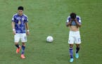 Japan’s Wataru Endo, left, and Hidemasa Morita react as they leave the field after their loss in the World Cup, group E soccer match between Japan a