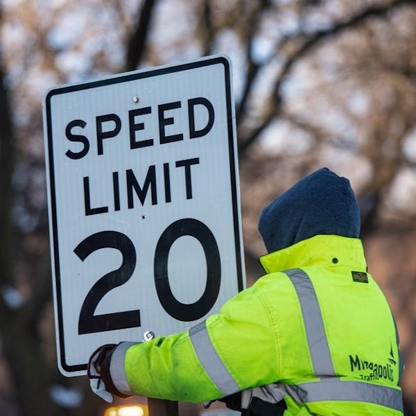 A worker put up a sign on Kenwood Parkway as reduced speed limit of 20 mph on Minneapolis parkways took effect.