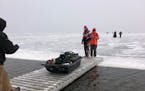 Anglers evacuated a sheet of ice using a bridge provided by JR’s Corner Access resort on the south side of Upper Red Lake on Monday, Nov. 28.  