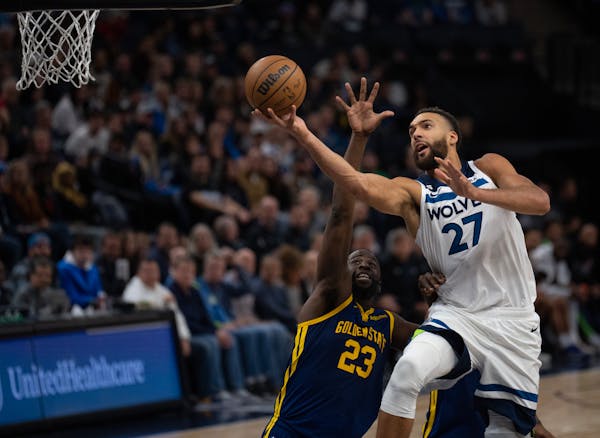 Timberwolves center Rudy Gobert (27) went up for a layup against Golden State forward Draymond Green on Sunday at Target Center.