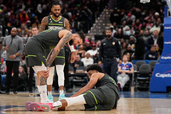 Wolves guard Austin Rivers checked on teammate Karl-Anthony Towns on Monday after Towns was injured in a game in Washington.