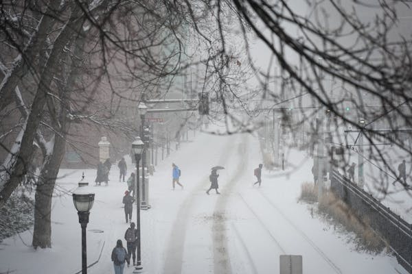Students make their way across a snowy University of Minnesota campus on Tuesday.