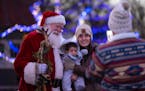 Santa posed for a photo with Brenda Madrid and son Marcelo, 6 months, as dad Sergio took a photo at Holidazzle in Loring Park in Minneapolis.
