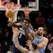 Timberwolves guard Anthony Edwards passed out of traffic and the defense of Grizzlies center Steven Adams in the first quarter at Target Center on Wed
