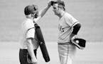 Home plate umpire John Flaherty checks Cleveland pitcher Gaylord Perry’s cap for an illegal substance during a game in Milwaukee in 1973.