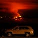 A man talks on a phone in his car alongside Saddle Road as the Mauna Loa volcano erupts Nov. 30, 2022, near Hilo, Hawaii.