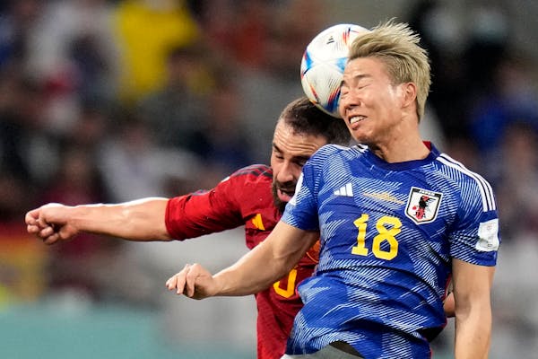Japan’s Takuma Asano, right, and Spain’s Dani Carvajal went for a header during a World Cup match won 2-1 by Japan in Doha, Qatar, on Thursday.