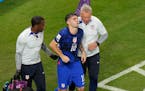 Christian Pulisic of the United States is helped by team doctors after he scoring his side's opening goal during the World Cup group B soccer match be