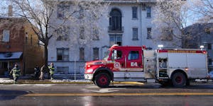 A member of the state Fire Marshal’s office and Minneapolis firefighters talked with someone outside the scene of a building fire Saturday in Minnea