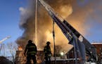 Minneapolis firefighters work a fire from an aerial ladder truck as a fire destroyed an empty apartment complex in the 2300 block of Lyndale Ave. S. I