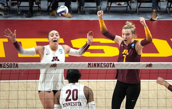 Rachel Kilkelly and CC McGraw celebrate a point in the first game against UNI on Saturday at Maturi Pavilion