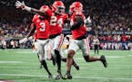 Georgia defensive back Malaki Starks (24) reacts as Georgia defensive back Christopher Smith (29) returns a blocked LSU field goal attempt for a touch