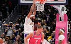 Los Angeles Lakers forward Anthony Davis, left, dunks against Washington Wizards centers Daniel Gafford (21) and Kristaps Porzingis (6) during the sec