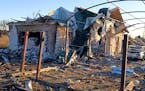 In this photo provided by the Zaporizhzhia region military administration, a damaged building and a car are seen after a Russian strike in the village