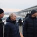 Russian President Vladimir Putin, center, and Deputy Prime Minister Marat Khusnullin, left, visit the Crimean Bridge connecting Russian mainland and C
