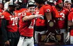 Georgia quarterback Stetson Bennett gestured to the crowd during the trophy presentation after the SEC Championship.