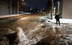 Ryan Merchant signaled to a co-worker a block away as they observed the water gushing downhill on 30th Avenue N. Monday night, Dec. 5, 2022, in Minnea