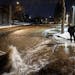 Ryan Merchant signaled to a co-worker a block away as they observed the water gushing downhill on 30th Avenue N. Monday night, Dec. 5, 2022, in Minnea
