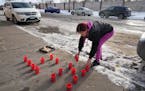 Tonya Medvec set candles along Hudson Road in St. Paul on Tuesday near where her nephew, Howard Johnson, died.
