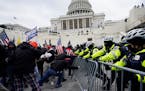 FILE - Insurrectionists loyal to President Donald Trump try to break through a police barrier, Wednesday, Jan. 6, 2021, at the Capitol in Washington.