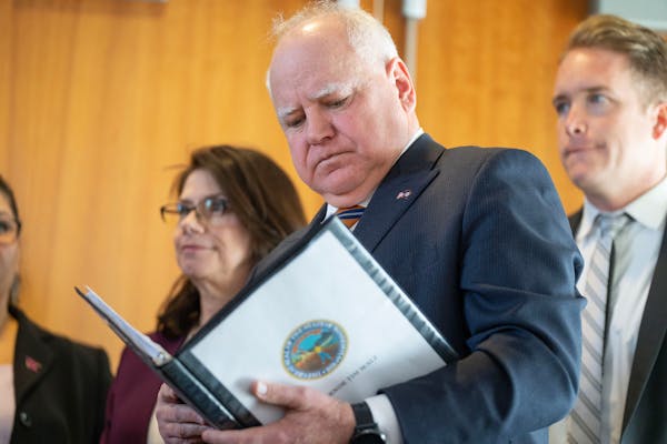 Gov. Tim Walz reviewed notes before speaking about Minnesota’s budget and economic forecast Tuesday at the Minnesota Department of Revenue in St. Pa
