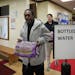 Buba Jaiteh, a Minneapolis resident affected by a water main freeze and break in the city, picked up bottled water distributed by the city at Farview 