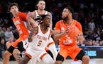 Illinois’ Jayden Epps (3) eyes the basket against Texas’ Marcus Carr (5) in overtime during the team’s NCAA college basketball game in the Jimmy