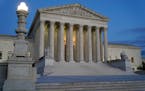 FILE - Light illuminates part of the Supreme Court building at dusk on Capitol Hill in Washington, Nov. 16, 2022. The court is set to hear arguments o