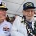 Ira Schab, 102, right, who survived the attack on Pearl Harbor as a sailor on the USS Dobbin, talks with reporters while sitting next to his son, reti