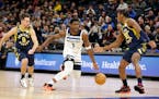 Timberwolves guard Anthony Edwards (26 points) dribbled between Pacers guards T.J. McConnell (9) and Bennedict Mathurin (00) in the first quarter of t