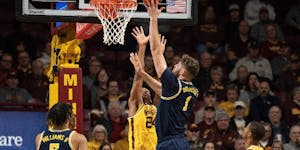 Gophers forward Jaden Henley tried to defend against Wolverines center Hunter Dickinson as he shot during the first half at Williams Arena on Thursday