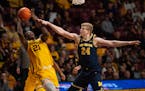 Gophers forward Pharrel Payne tried to get a shot off while being fouled by Wolverines forward Youssef Khayat during the second half of Minnesota’s 