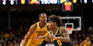 Michigan guard Dug McDaniel (0) stole the ball from Gophers guard Ta’lon Cooper (55) during Thursday’s game.
