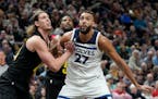 Jazz forward Kelly Olynyk and Timberwolves center Rudy Gobert look for a rebound during the first half Friday