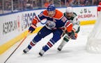 The Wild’s Jacob Middleton and Edmonton’s Leon Draisaitl battle for the puck during the second period Friday in Edmonton