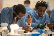 Lake Street Works participants Zakaria, left, and Abdqadar worked together on an electrical training project Tuesday evening, December 13, 2022 in Min