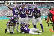 Minnesota Vikings players celebrate against the Dolphins.